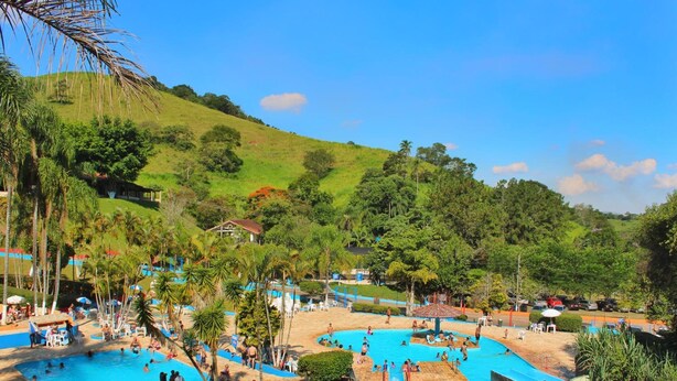 A resort with multiple swimming pools, palm trees, and a hilly backdrop. - Estância Solazer (Santa Isabel)
