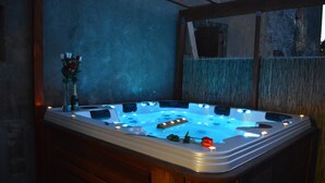 A hot tub with a wooden base, surrounded by a window with a view of a fence. - Your little paradise;) (ESPONDEILHAN)