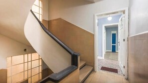 Escadaria que leva a um patamar com vista para um corredor.