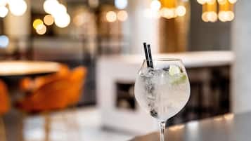 A glass with a straw and ice cubes on a bar counter.