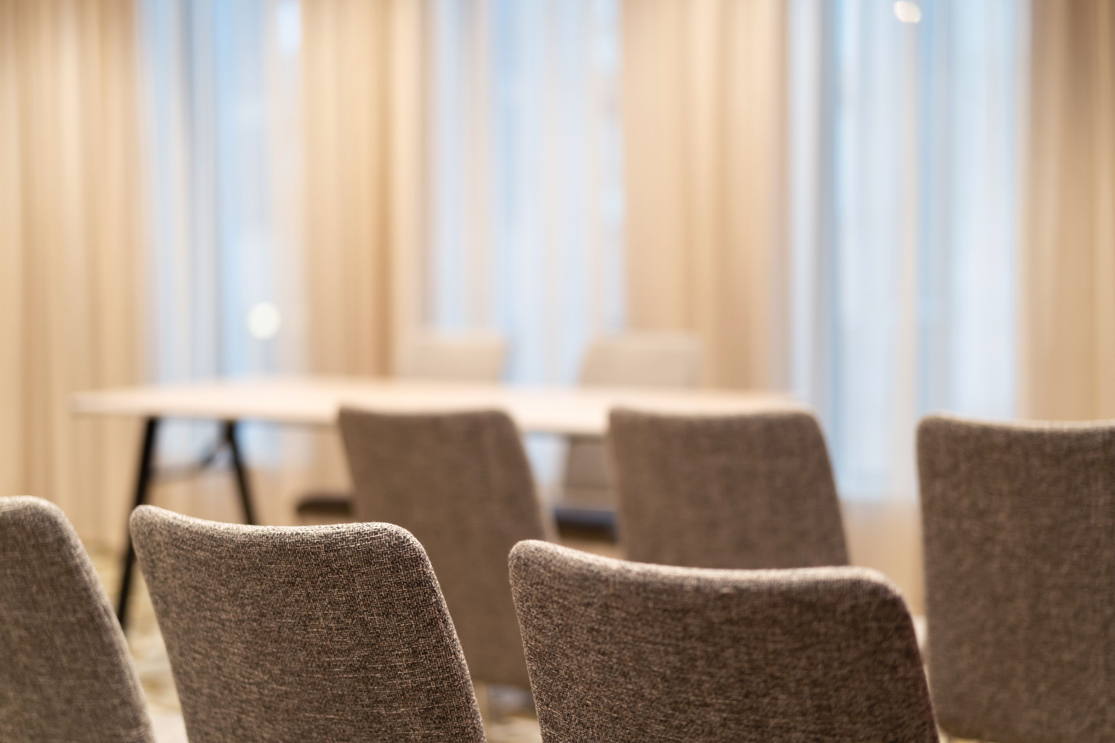 Un salón de conferencias con una larga mesa y varias sillas.