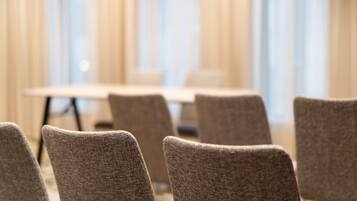 Un salón de conferencias con una larga mesa y varias sillas.
