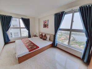 Enjoy a serene view of the water from the comfort of this stylish room, featuring a large bed and expansive window.