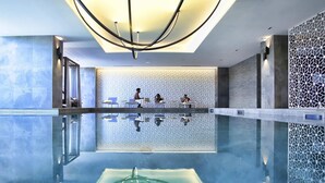 A modern indoor pool with a clear water surface, a geometric ceiling design, and a textured wall in the background. - Novotel Convention And Spa (Antananarivo)