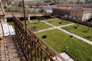 A courtyard with a central lawn, surrounded by buildings with red-tiled roofs. - Casa Regina Montis Regalis (Vicoforte)