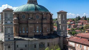 A large historic building with a prominent dome and clock tower, surrounded by a well-maintained courtyard.