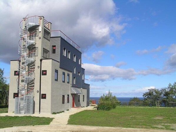 A multi-story building with a modern architectural design, featuring a prominent spiral staircase on the left side.