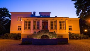 A stately building with a symmetrical facade, large windows, and a central entrance with a stone archway. - Saka Cliff Hotel & SPA (Saka)