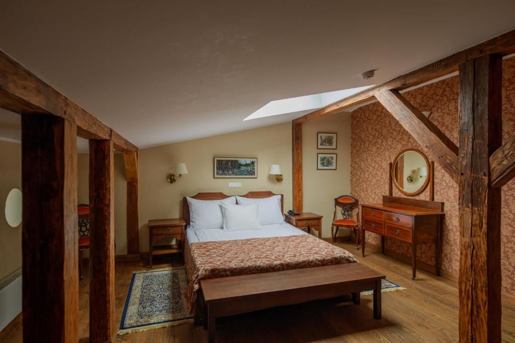 A bedroom with a bed, bedside tables, a dresser, and a mirror.