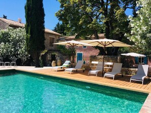 Una piscina al aire libre de temporada, sombrillas