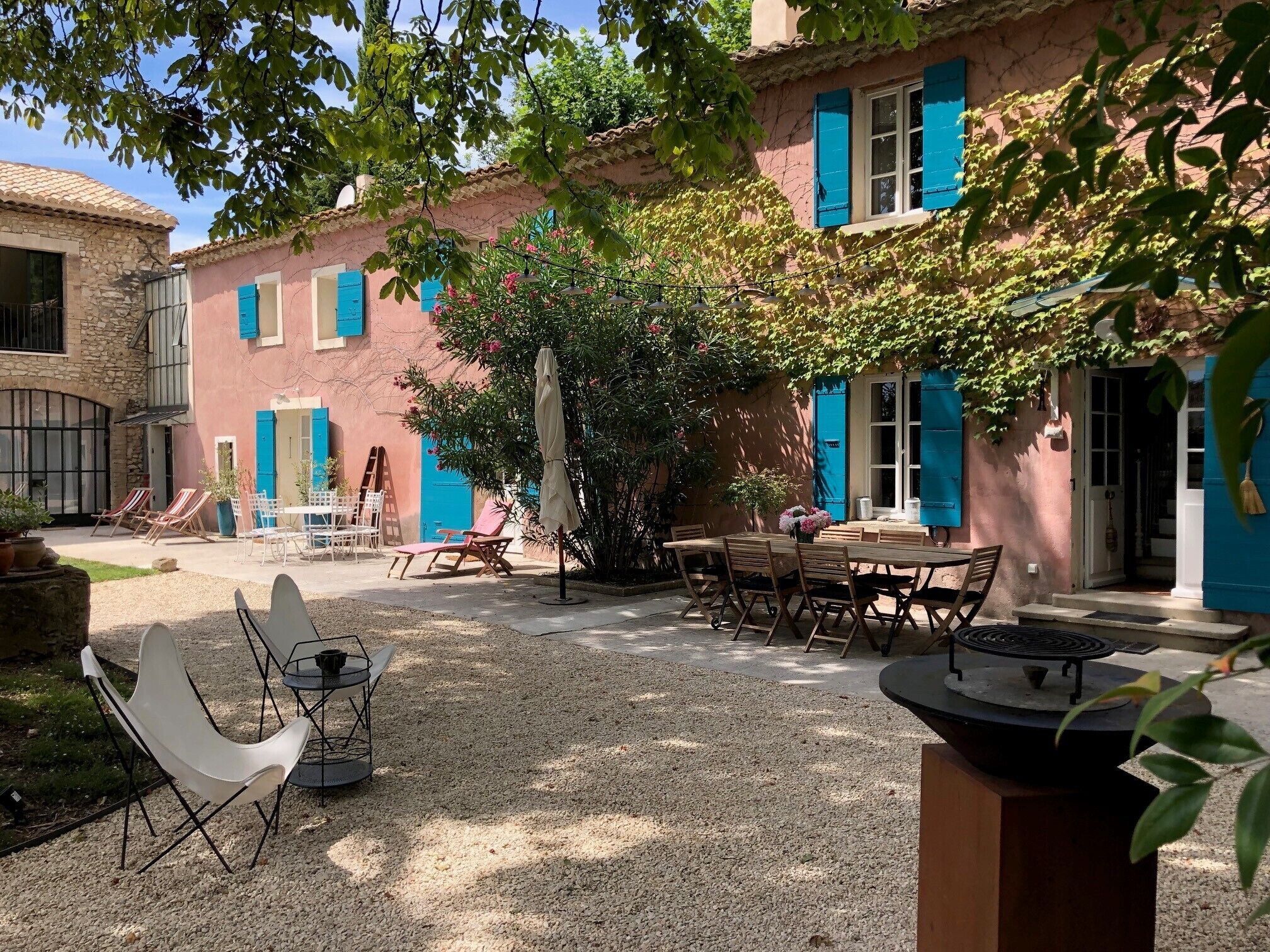 A courtyard with outdoor seating, a table, and a grill.