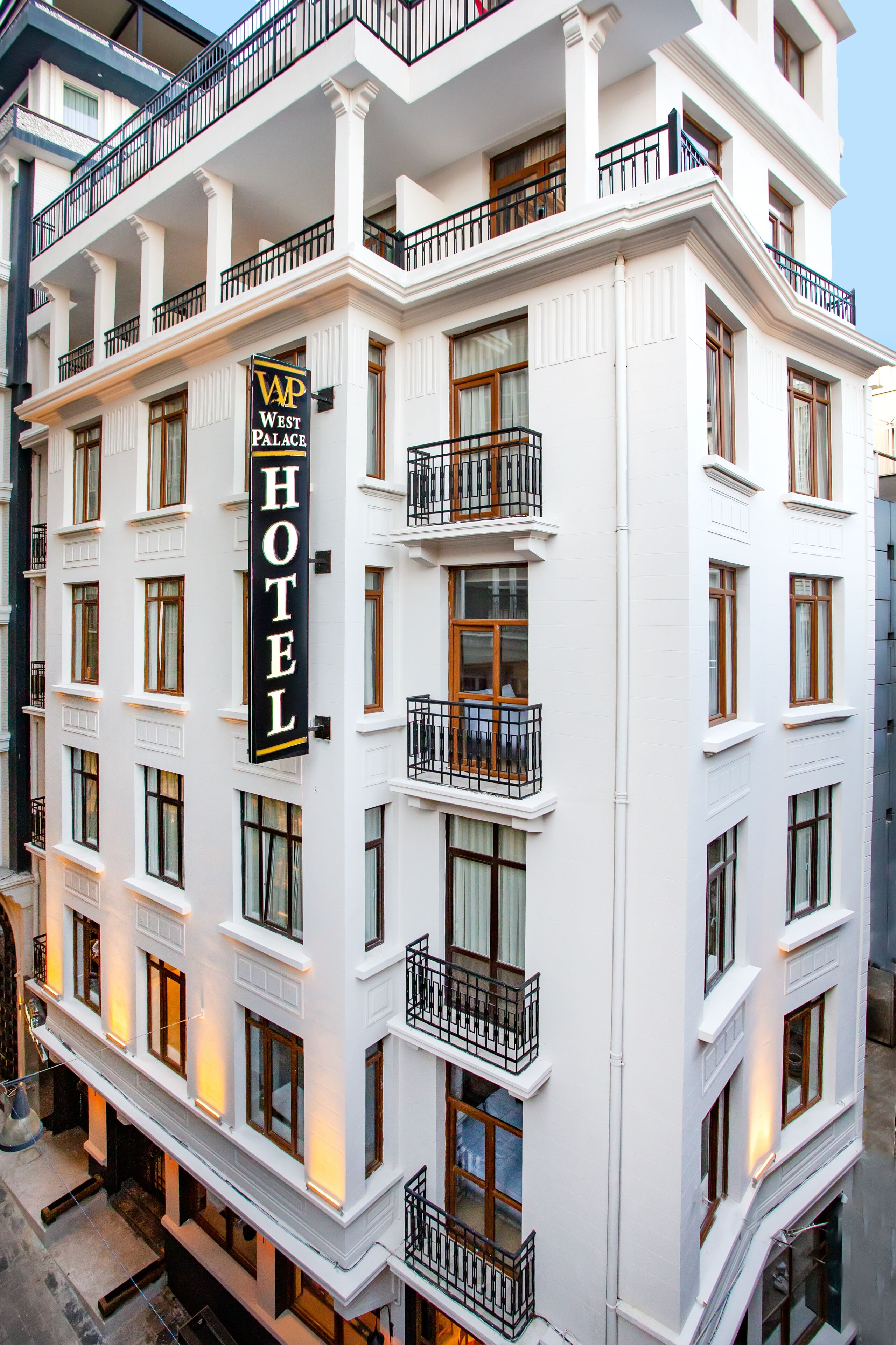 A multi-story hotel with a prominent 'West Palace Hotel' sign, large windows, and balconies.