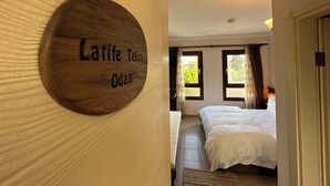 A hotel room with a wooden sign reading "Latife Tekin Oda". - Alibeyhan Otel (Ayvalik)
