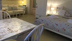 A room with a bed, a chair, a table, a wardrobe, and a painting on the wall. - Gästeträume (Bremen)