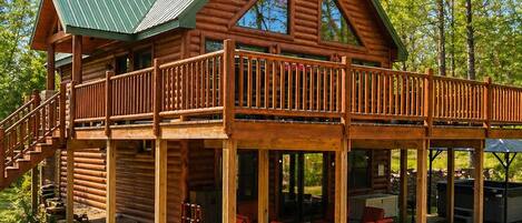 A log cabin with a covered deck and outdoor seating area.