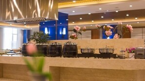 A modern kitchen with a central island, stainless steel appliances, and decorative flowers. - GreenTree Eastern Handan Daming County Bus Station (Handan)