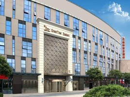 A modern hotel building with a prominent entrance and a large glass facade.