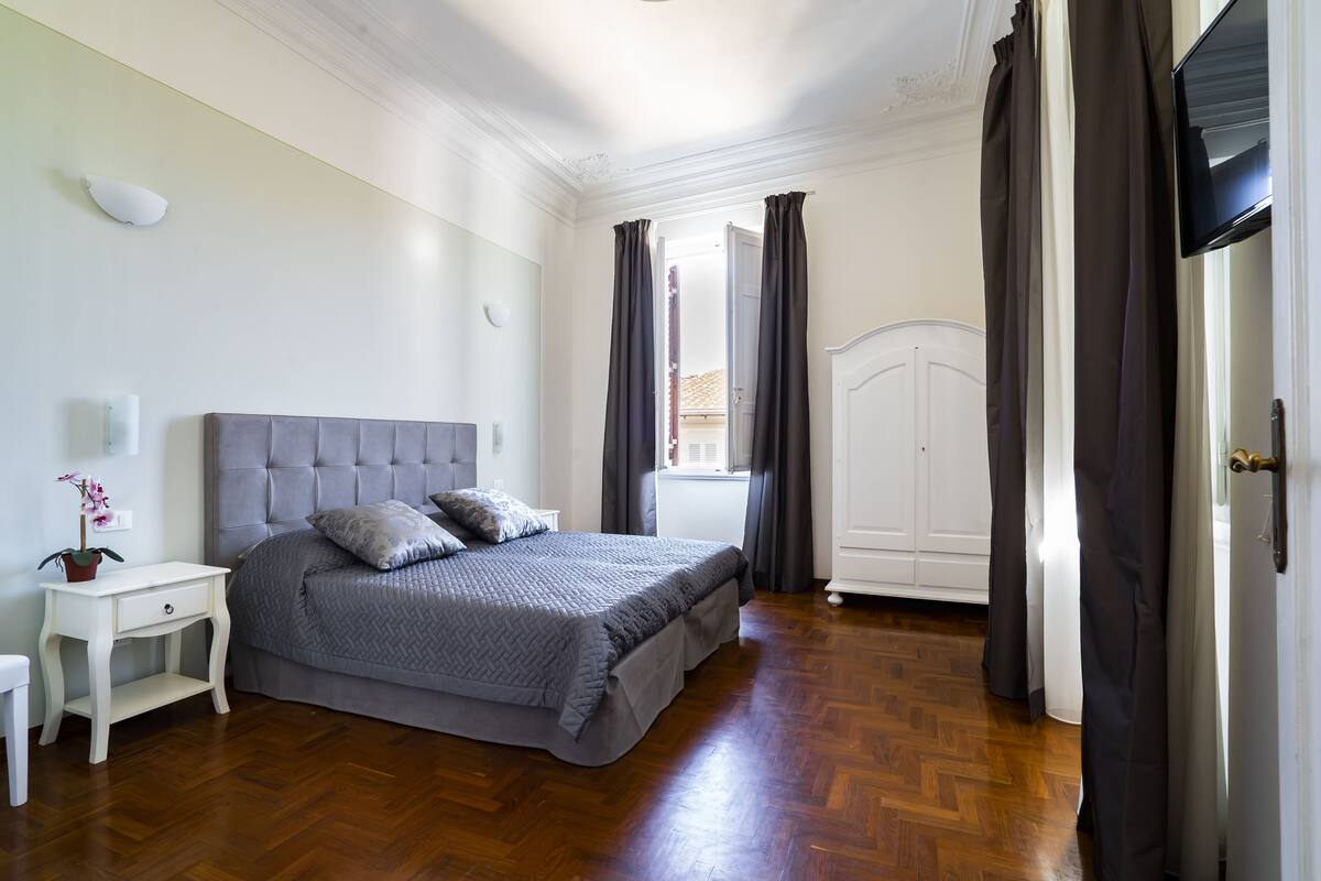 Een slaapkamer met een bed, nachtkastje en een kledingkast.