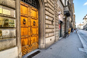 A historic building with a large wooden door, plaques, and a bicycle parked outside. - Live Florence Guesthouse (Florence)