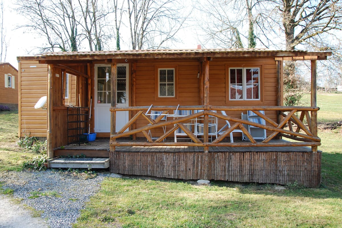 A small wooden cabin with a porch and a door.