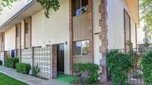 Un bâtiment à deux étages, doté d’une façade beige, de détails en briques et d’une entrée fermée par un portail.