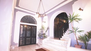 A spacious lobby with marble flooring, a grand staircase, and multiple potted plants. - Ludovisi Decò (Rome)