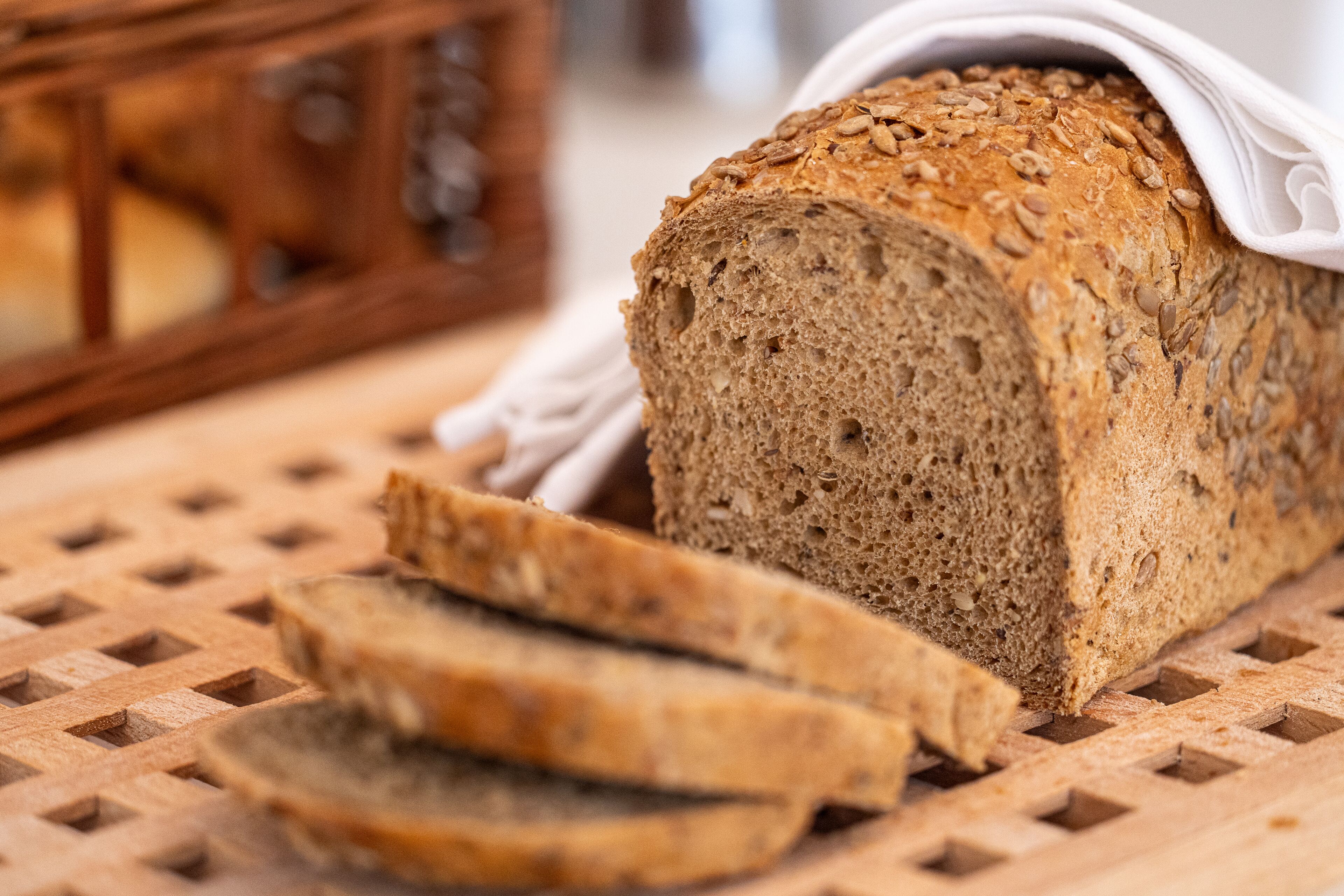 Ein Brot aus Vollkorn mit Saaten auf einem Holzschnittbrett.
