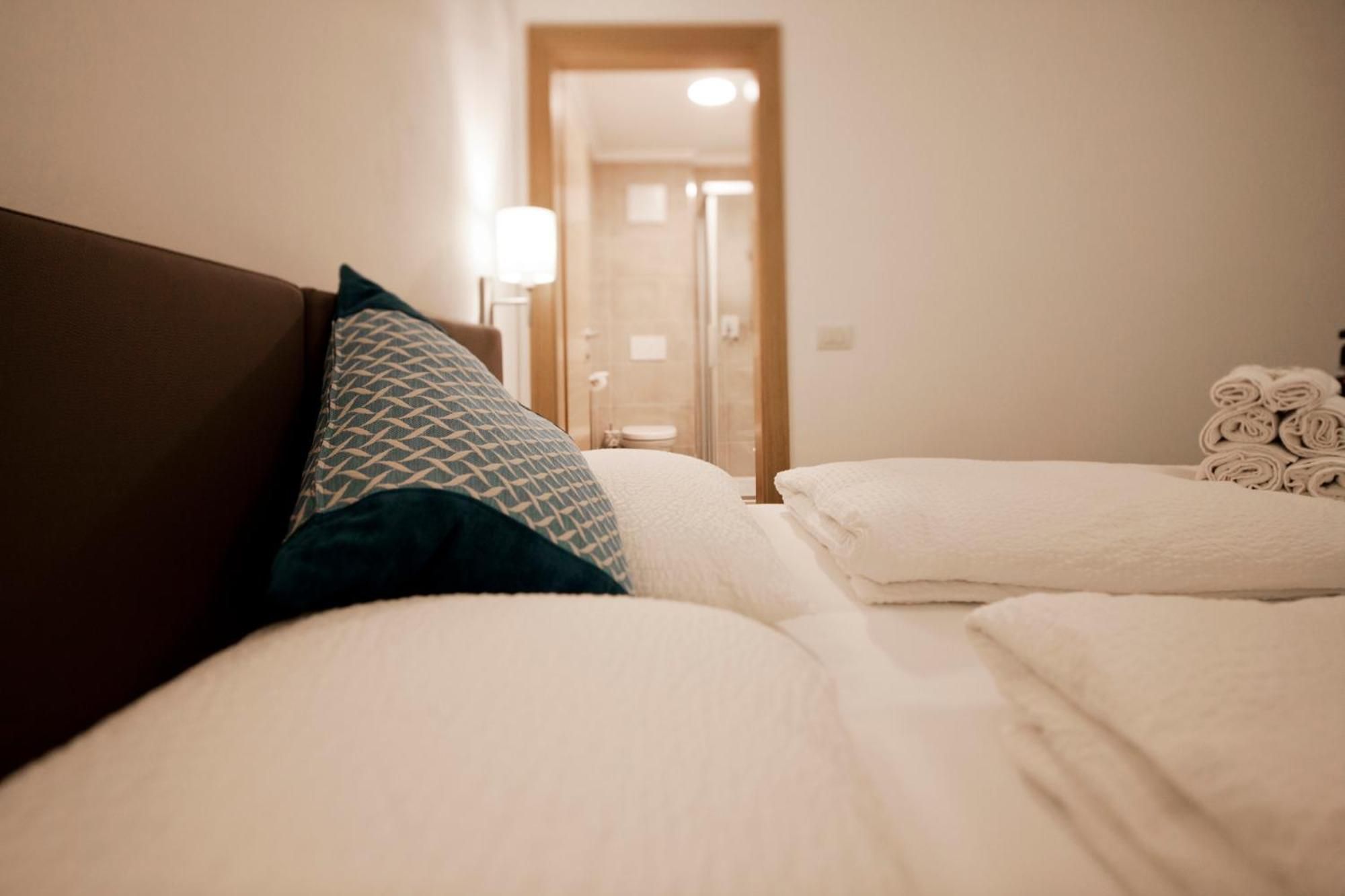 Et hotelværelse med to senge, et natbord og en lampe.