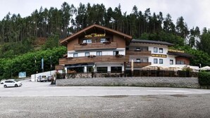 Un hôtel doté d’une façade en bois, de nombreux balcons et d’un espace de stationnement.