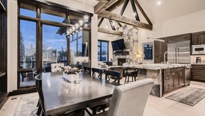 A modern kitchen with a large island, built-in appliances, and a stone accent wall. - Closest to Gondola | Shock Hill Majestic | Views! (Breckenridge)