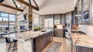 A modern kitchen with granite countertops, dark cabinetry, and stainless steel appliances. - Closest to Gondola | Shock Hill Majestic | Views! (Breckenridge)