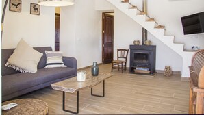 A living room with a sofa, a coffee table, a fireplace, and a staircase. - Finca Sa Caseta Biniali (Sencelles)