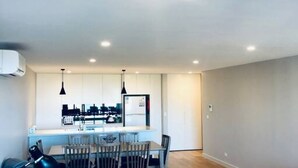 Une cuisine moderne dotée d’un îlot central, de luminaires suspendus et d’un coin repas avec des chaises.