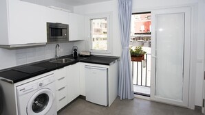 A compact kitchen with a washing machine, a microwave, and a sink. - MONKÓ KIWI TROPYCAL APARTMENT (Torremolinos)