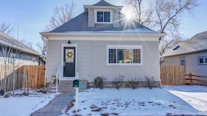 A single-story house with a grey roof, white siding, and a front door with a wreath. - 1893 Classic 4 Blocks From Great Dining & Shops (Colorado Springs)
