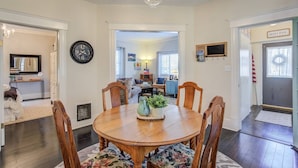 A dining room with a wooden table and chairs, a clock on the wall, and a chandelier. - 1893 Classic 4 Blocks From Great Dining & Shops (Colorado Springs)