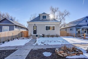 A residential house with a front yard, a mailbox, and a wooden fence.