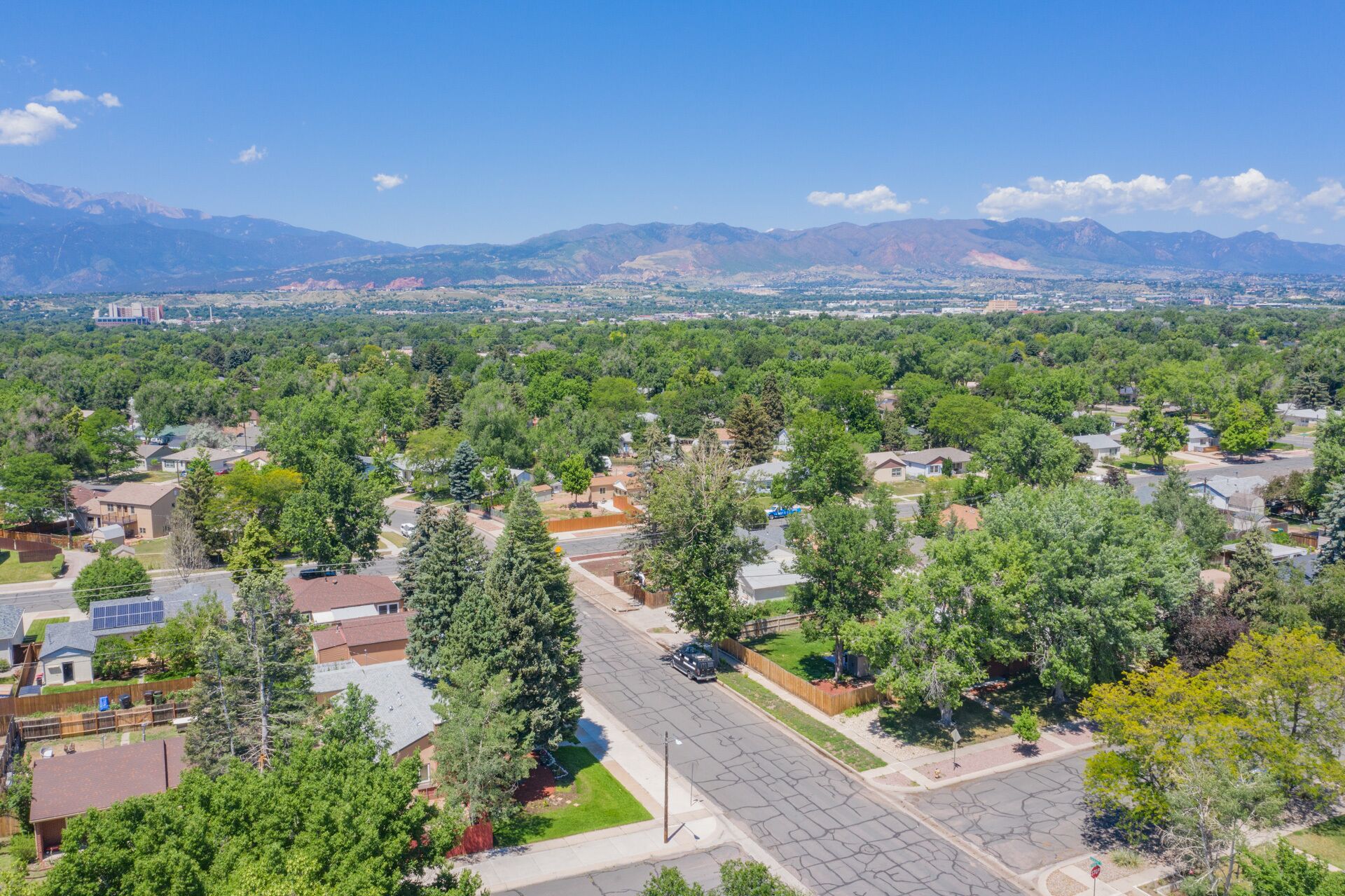 A residential area with houses, streets, and a mountainous backdrop.