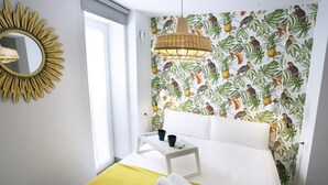 A hotel room with a bed, a bedside table with two cups, a yellow towel, and a mirror with a sunburst frame. - MONKÓ LEMON TROPYCAL APARTMENT (Torremolinos)