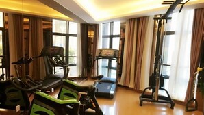 Un gimnasio con cintas de correr, bicicletas estáticas y una máquina de remo.