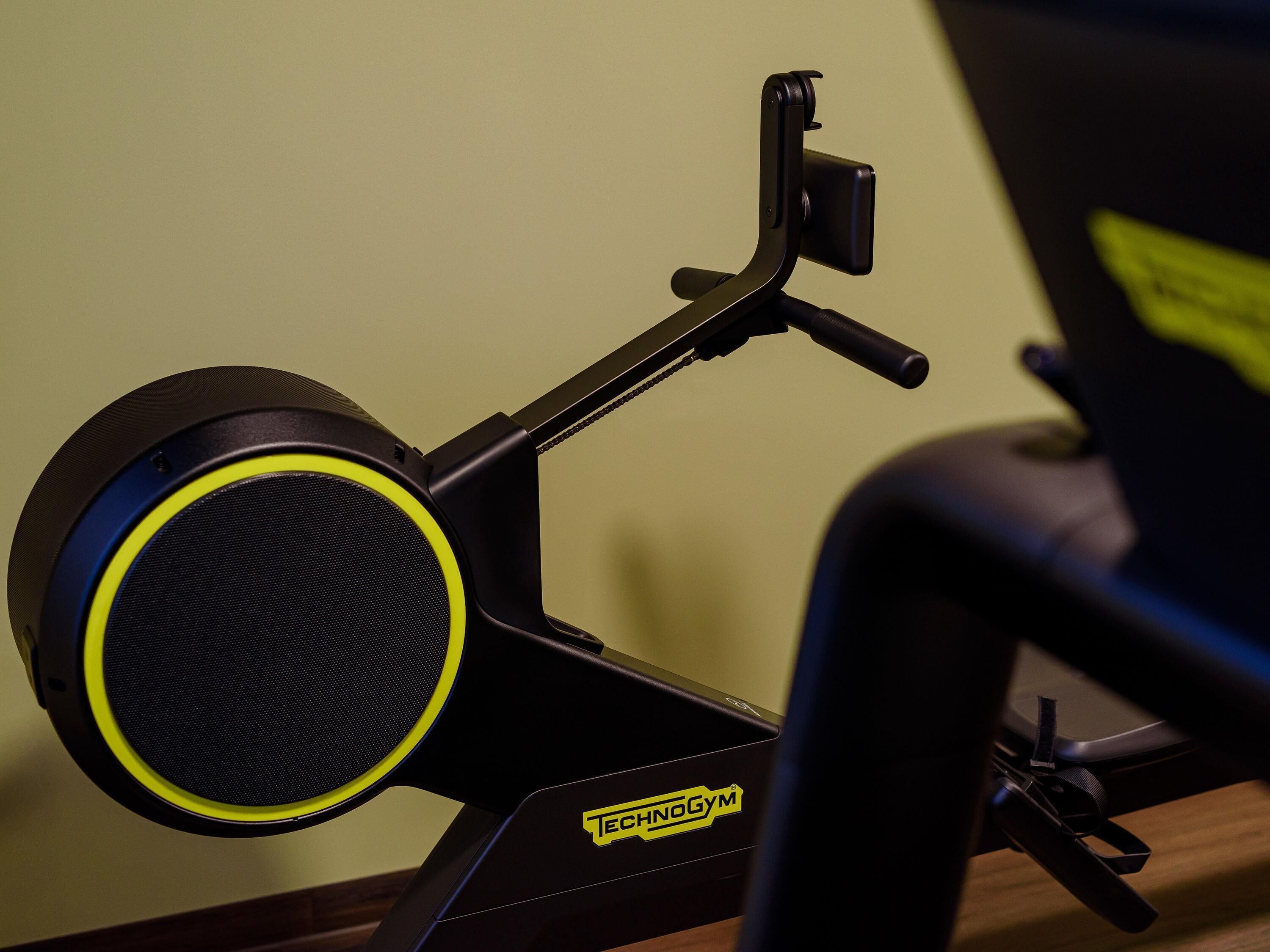 A stationary exercise bike with a control panel and a handlebar.