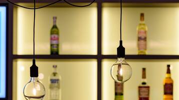 Un área de bar con luces colgantes y estantes llenos de botellas de licores.