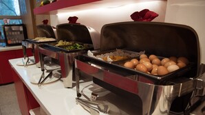 Un buffet proposant une variété de plats et d’ustensiles.