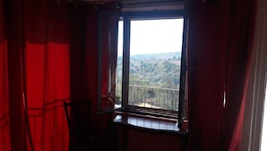 A room with a large window overlooking a scenic landscape. - Cascina Binelli (Dogliani)