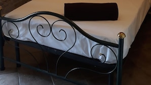 A bedroom with a bed, a nightstand, a lamp, a window, and a wall-mounted shelf. - Cascina Binelli (Dogliani)