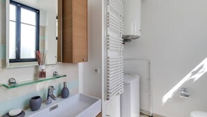 Ein modernes Badezimmer mit Waschbecken, Spiegel und Handtuchheizkörper.
