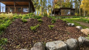 A modern house with a wooden deck and a stone pathway leading to the entrance.