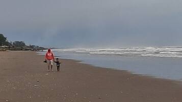 Aan het strand, wit zand, ligstoelen aan het strand, parasols