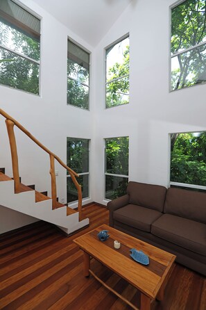 A modern interior with a wooden staircase, a brown sofa, and a coffee table with decorative items.