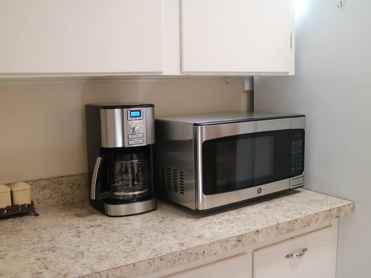 A kitchen with a coffee maker and a microwave on a countertop.